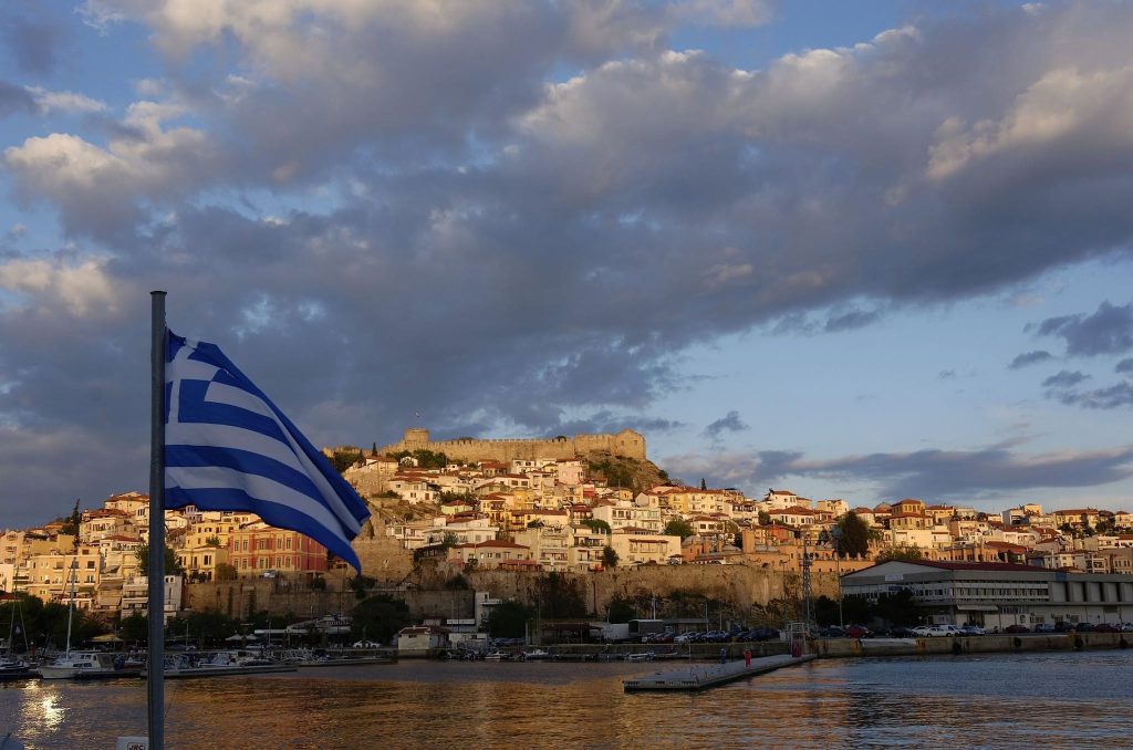 Κάστρο Καβάλας και η παλιά πόλη στο ηλιοβασίλεμα με την ελληνική σημαία